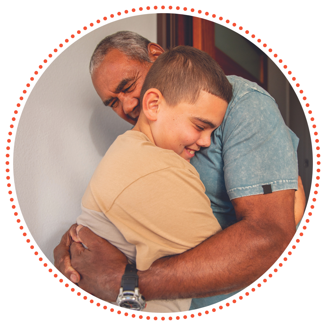 A photo of a father and son hugging each other in the warm summer sun